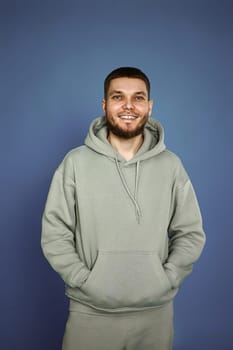 handsome bearded man in sweatshirt on gray background.