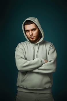 handsome bearded man in sweatshirt looking at the camera on gray background.