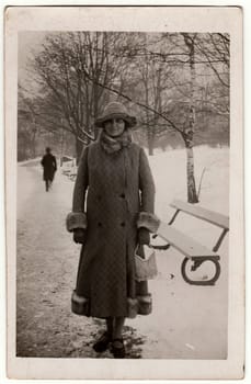 THE CZECHOSLOVAK REPUBLIC - CIRCA 1940s: Vintage photo shows woman in a winter time. Woman wears a long coat with fur bordering. Retro black and white photography. Circa 1940s.