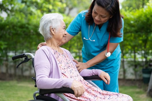 Doctor help and care Asian senior woman patient sitting on wheelchair at park in nursing hospital ward, healthy strong medical concept.