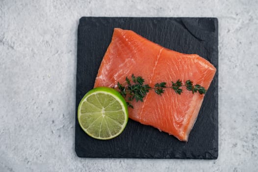 Fresh salmon with , greens and lime on concrete background