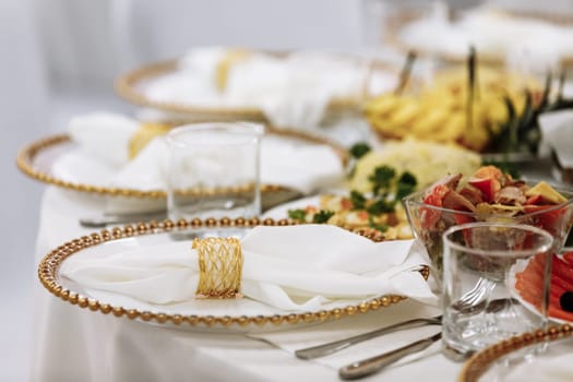 a table with a tablecloth, a beautiful serving of white dishes, a beautiful plate, dinner in a restaurant.