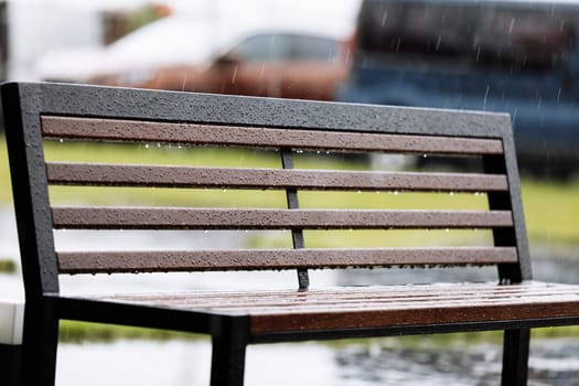 wooden with metal bench under the rain outdoors. High quality photo.