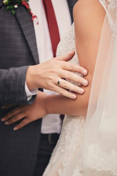 cropped photo of couple in love, bride and groom cuddle and look at each other. This day is the first of many beautiful days together