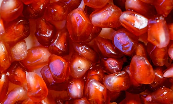 This is a close-up photograph of pomegranate seeds, showing their vibrant red color and texture. High quality photo