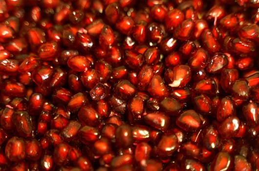 Texture of peeled red pomegranate seeds. Close-up.