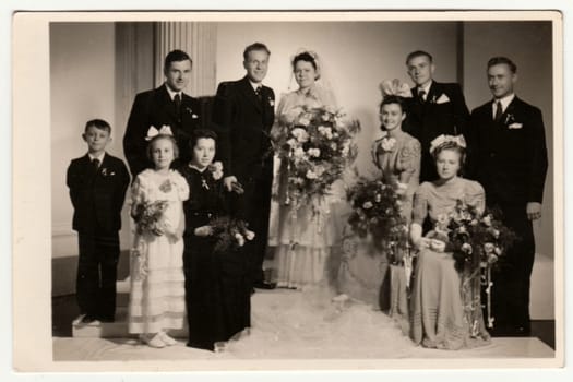 MLADA BOLESLAV, THE CZECHOSLOVAK REPUBLIC - CIRCA 1945: Vintage photo shows newlyweds, bridesmaids, bridesmen and other wedding guests. Retro black and white photography. Circa 1950s.