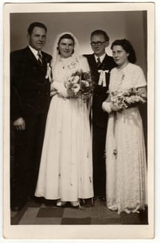 PISEK, THE CZECHOSLOVAK SOCIALIST REPUBLIC - CIRCA 1950s: Vintage photo shows newlyweds and bridesman with bridesmaid. Retro black and white photography. Circa 1920s.