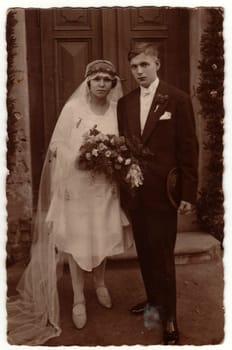 PRAHA (PRAGUE), THE CZECHOSLOVAK REPUBLIC - CIRCA 1930s: Vintage photo shows newlyweds go from wedding ceremony. Retro black and white photography. Circa 1930s.