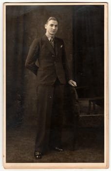 THE CZECHOSLOVAK REPUBLIC - CIRCA 1920s: Vintage photo shows young man poses in photography studio. Retro black and white photography. Circa 1920s.