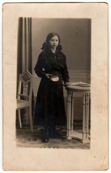 THE CZECHOSLOVAK REPUBLIC - CIRCA 1920s: Vintage photo shows young girl poses in a photography studio. Retro black and white photography. Circa 1920s.