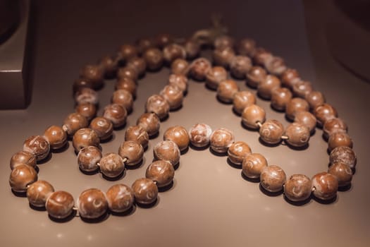 Rosary or prayer beads, on dark background.