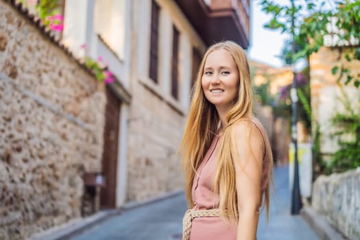 Woman tourist in Old town Kaleici in Antalya. Turkiye. Panoramic view of Antalya Old Town port, Taurus mountains and Mediterrranean Sea, Turkey.