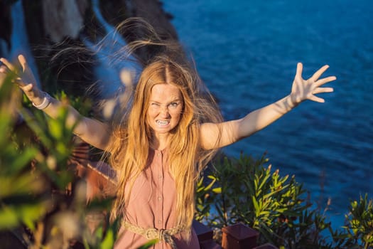Woman with crazy hair on the background of Duden waterfall in Antalya. Famous places of Turkey. Lower Duden Falls drop off a rocky cliff falling from about 40 m into the Mediterranean Sea in amazing water clouds. Tourism and travel destination photo in Antalya, Turkey. Turkiye.
