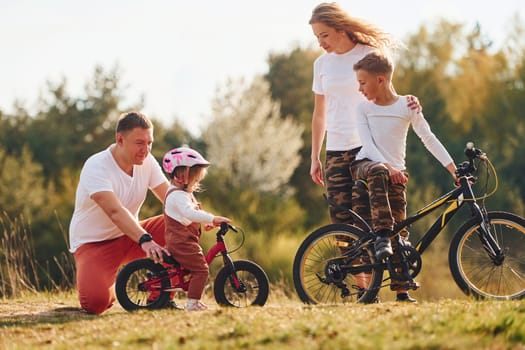 With bikes. Happy family spending weekend together outdoors near the forest. With daughter and son.