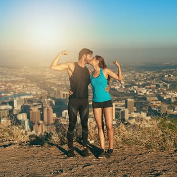 Become a workout power couple. a young couple flexing their muscles while out for a workout