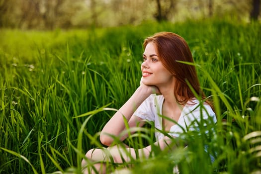 adorable woman sitting in nature resting in tall grass. High quality photo