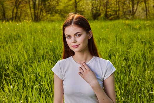portrait of a pensive woman sitting in the grass in nature. High quality photo