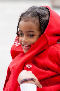 closeup of an african american girl dressed in red with two braids. High quality photo. close-up of an African American girl dressed in red with two braids and beautiful eyes