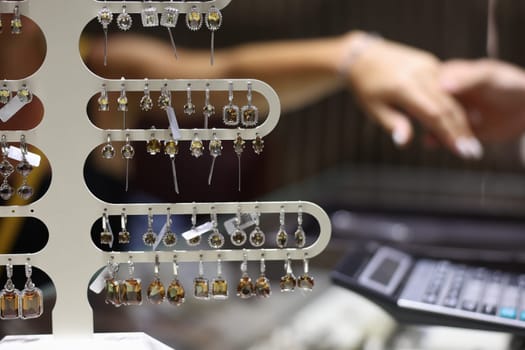 Lot of precious earrings with stones sold in jewelry store closeup. Jewelry and bijouterie concept