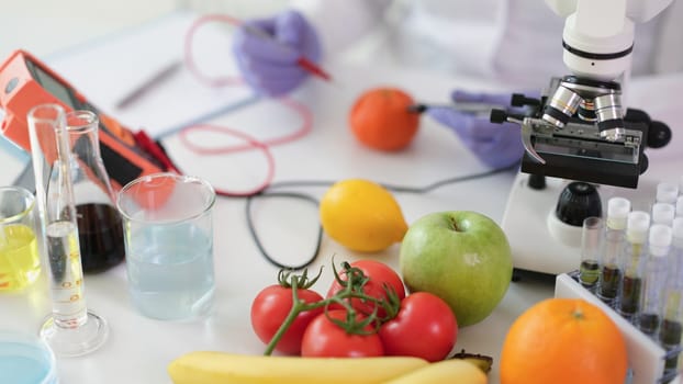 Scientist chemist studying amount of toxic substances in vegetables and fruits in chemical laboratory. Food quality control nitrate content concept