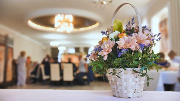 Wedding celebration background concept. A bouquet of flowers on the background of the banquet guests who are eating