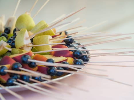 Fruit on a stick at a wedding celebration with light illumination