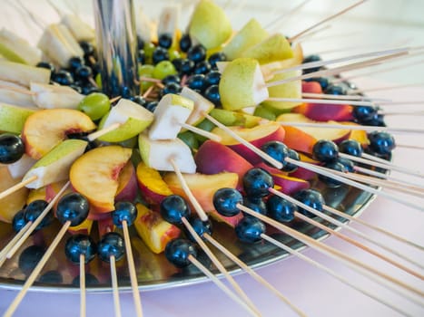 Fruit on a stick at a wedding celebration with light illumination
