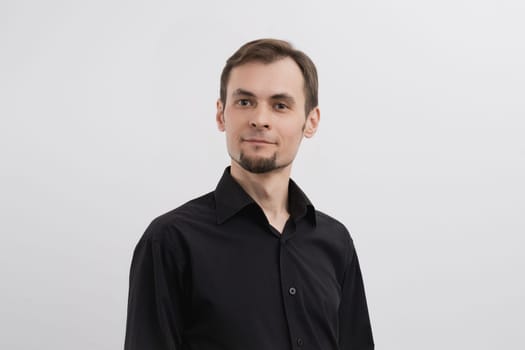 Just a portrait of caucasian man in his 30s with a beard and in a black shirt on a white background.