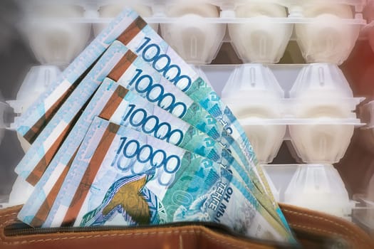 Rising prices for eggs in Kazakhstan. Tenge in a wallet against the background of a counter with eggs.