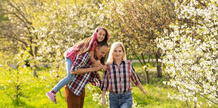 Happy young family spending time together outside in green nature.