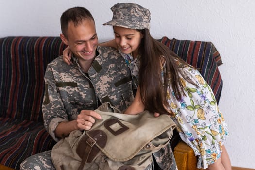 Little child is very happy her father came back from army. Little kid is hugging her father.