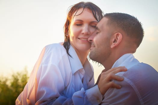 Wet happy Couple Outdoor relaxin, having fun and hugs on nature in park. Family or lovers have date and rest outdoors. Concept of love and friendship