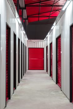 Corridor of self storage unit with red doors. Rental Storage Units