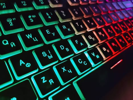 Bright multicolored backlit computer keyboard close-up on the table. Computer keyboard.