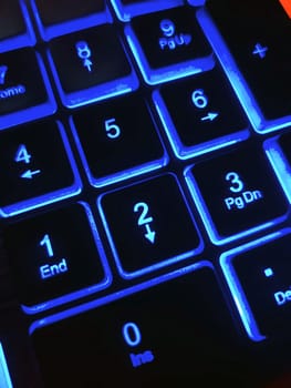 Bright multicolored backlit computer keyboard close-up on the table. Computer keyboard.