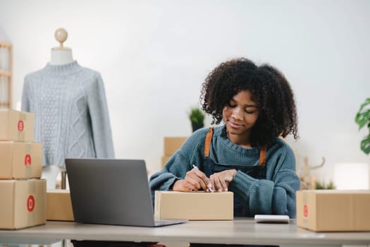 Startup small business entrepreneur SME, asian woman packing cloth in box. Portrait young Asian small business owner home office, online sell marketing delivery, SME e-commerce telemarketing concept...