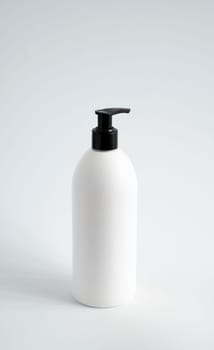 White unbranded bottle with a black dispenser isolated on white background. cosmetic packaging mockup with copy space. Bottle for a shower, gel, soap