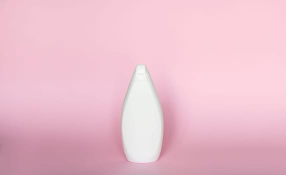 White bottle for liquid soap, shampoo, gel on pink background