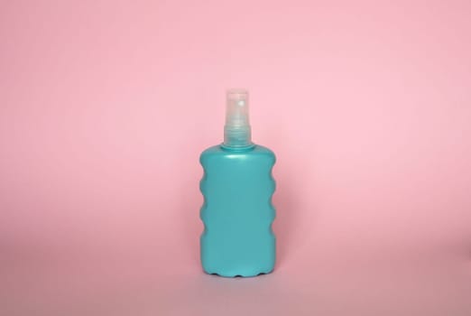 Blue blank unbranded cosmetic plastic bottle for shampoo, gel, lotion, cream, bath foam pink background