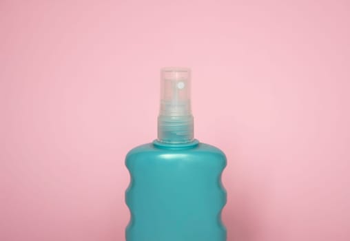 Blue blank unbranded cosmetic plastic bottle for shampoo, gel, lotion, cream, bath foam pink background