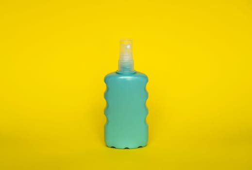 Blue blank unbranded cosmetic plastic bottle for shampoo, gel, lotion, cream, bath foam yellow background