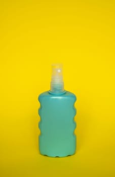Blue blank unbranded cosmetic plastic bottle for shampoo, gel, lotion, cream, bath foam yellow background