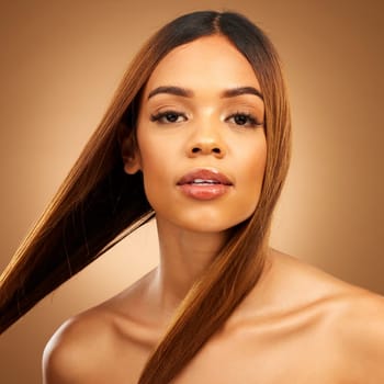 Haircare, beauty and serious portrait of woman in studio with straight hair, texture and salon shine. Latino model, healthy brunette hairstyle and natural keratin product on brown background space