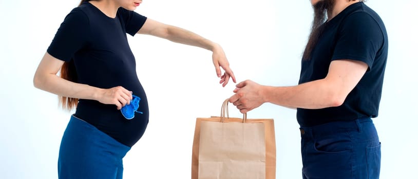 Portrait happy young pregnant woman and her husband with shopping bags and touching her big belly isolated on white background. Pregnancy shopping concept happy young family with shopping bags