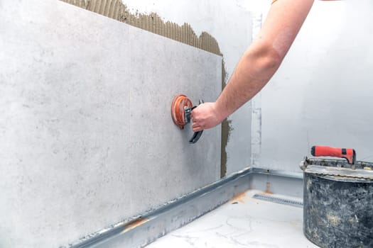 craftsman tiling the room with large format tiling. High quality photo