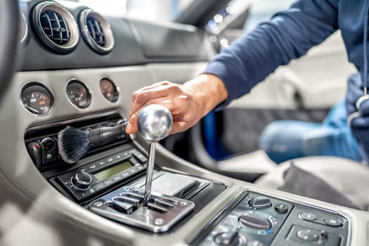 cleaning the interior of a luxury car with a brush. High quality photo