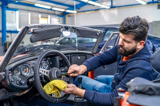 cleaning the interior of the old car with a brush and rag. High quality photo