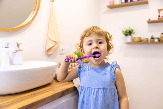 The child brushes his teeth in the bathroom. Selective focus. Nature.