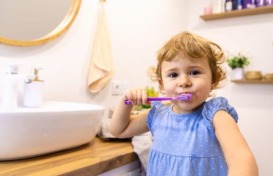 The child brushes his teeth in the bathroom. Selective focus. Nature.